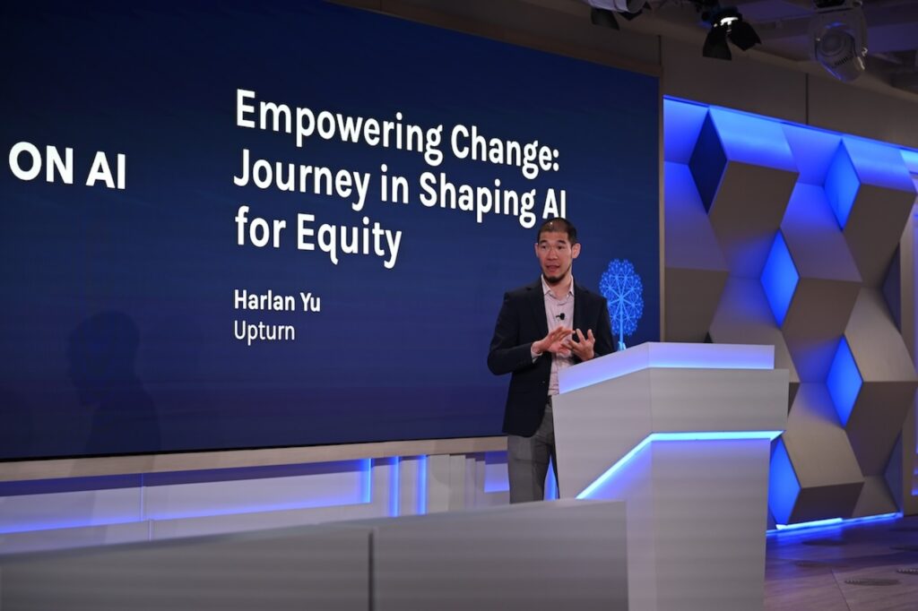 Harlan Yu presenting on stage at the AI & Philanthropy Forum